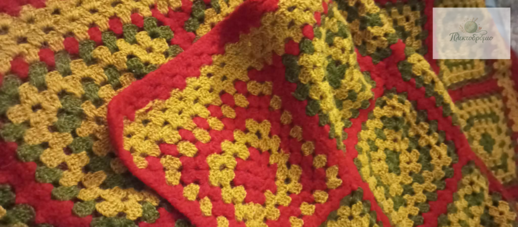 πλεκτή κουβέρτα σε έντονα χρώματα με λογότυπο της εταιρείας πλεκτοδρόμιο